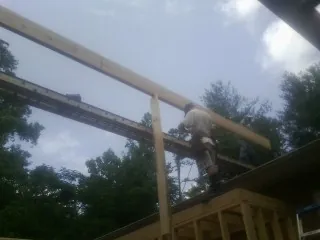 Carpenter setting a ridge beam over a new addition frame — Ice Dam Removal by Roofing Brothers in Deerfield
